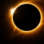 Total solar eclipse with corona visible against dark sky, natural phenomena tourism