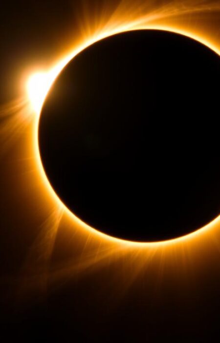 Total solar eclipse with corona visible against dark sky, natural phenomena tourism