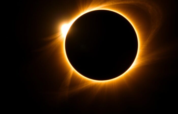 Total solar eclipse with corona visible against dark sky, natural phenomena tourism